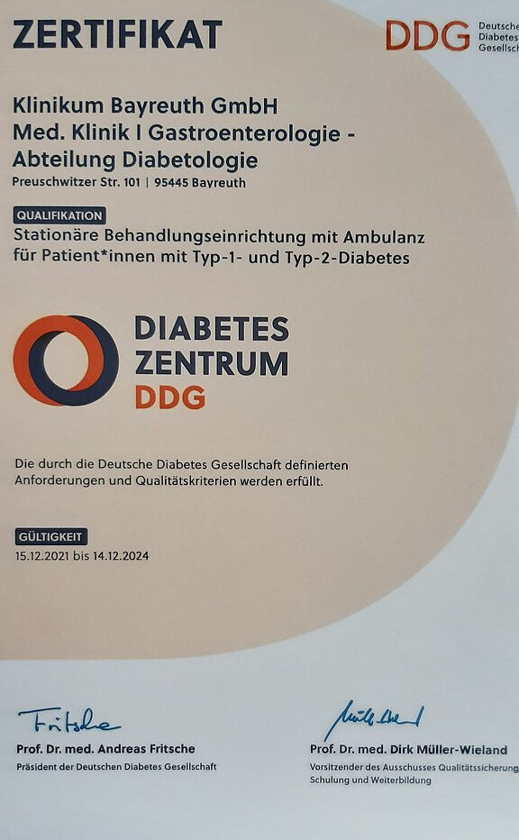 Zertifikat der Klinik Bayreuth GmbH für die Abteilung Diabetologie. Bestätigung der Qualifikation als stationäre Behandlungseinrichtung für Patienten mit Typ-1- und Typ-2-Diabetes. Gültig von 15. Dezember 2021 bis 14. Dezember 2024, unterzeichnet von den Verantwortlichen der Deutschen Diabetes Gesellschaft.