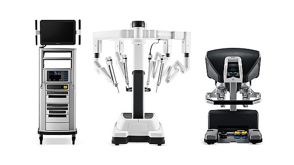 Das Bild zeigt ein chirurgisches Robotersystem in drei Teilen: links ein Bedienfeld mit Bildschirm, in der Mitte ein Roboterarm mit mehreren Instrumenten und rechts eine Steuereinheit. Alle Komponenten sind auf einem weißen Hintergrund platziert, um die Technologie hervorzuheben.