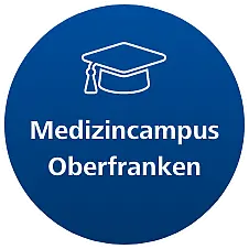 Medizincampus Oberfranken Kreisförmiges Logo des Medizincampus Oberfranken mit einem akademischen Hut-Symbol und dem Text „Medizincampus Oberfranken“ in weißer Schrift auf blauem Hintergrund.