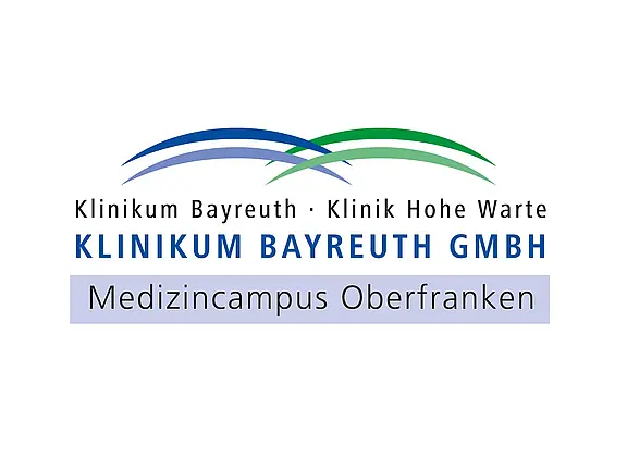 Logo des Klinikums Bayreuth GmbH: zwei geschwungene Bögen in Blau und Grün. Text: „Klinikum Bayreuth · Klinik Hohe Warte“ und darunter „KLINIKUM BAYREUTH GMBH“. Im unteren Balken steht „Medizincampus Oberfranken“.