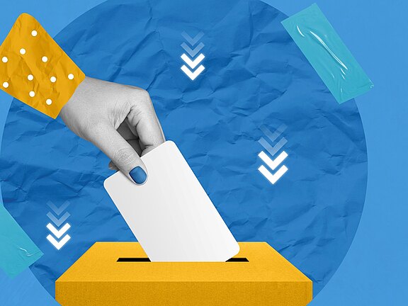 Eine Hand steckt einen weißen Stimmzettel in eine gelbe Wahlurne; nach unten gerichtete Pfeile betonen den Einwurf.