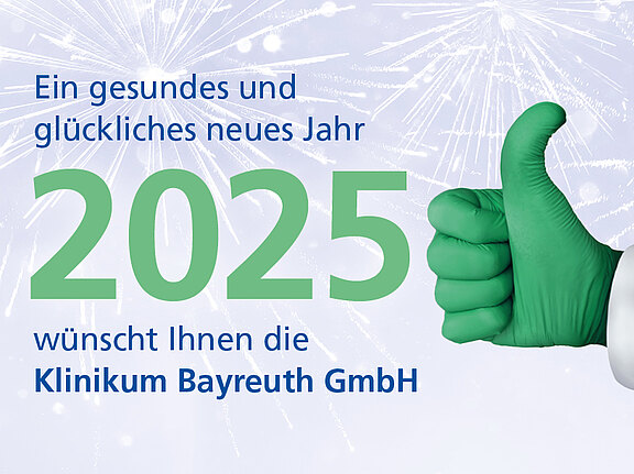 Neujahrsgruß des Klinikums Bayreuth: „Ein gesundes und glückliches neues Jahr 2025“. Zwei behandschuhte Hände (blau, grün) zeigen Daumen hoch vor dezentem Feuerwerks-Hintergrund.