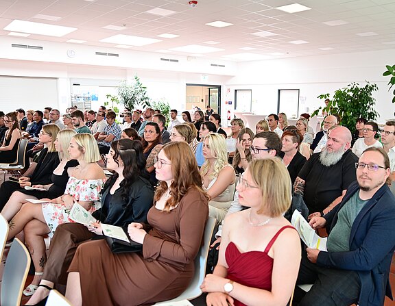 Schülerinnen, Schüler, Familien und Lehrkräfte feiern das Examen des Kurses 2022/25 der Krankenpflegeschule der Klinikum Bayreuth GmbH