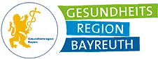 Logo der Gesundheitsregion Bayreuth: links ein goldener Löwe mit Äskulapstab in einem Kreis, rechts der Schriftzug „Gesundheitsregion Bayreuth“ auf grünen und blauen Balken.